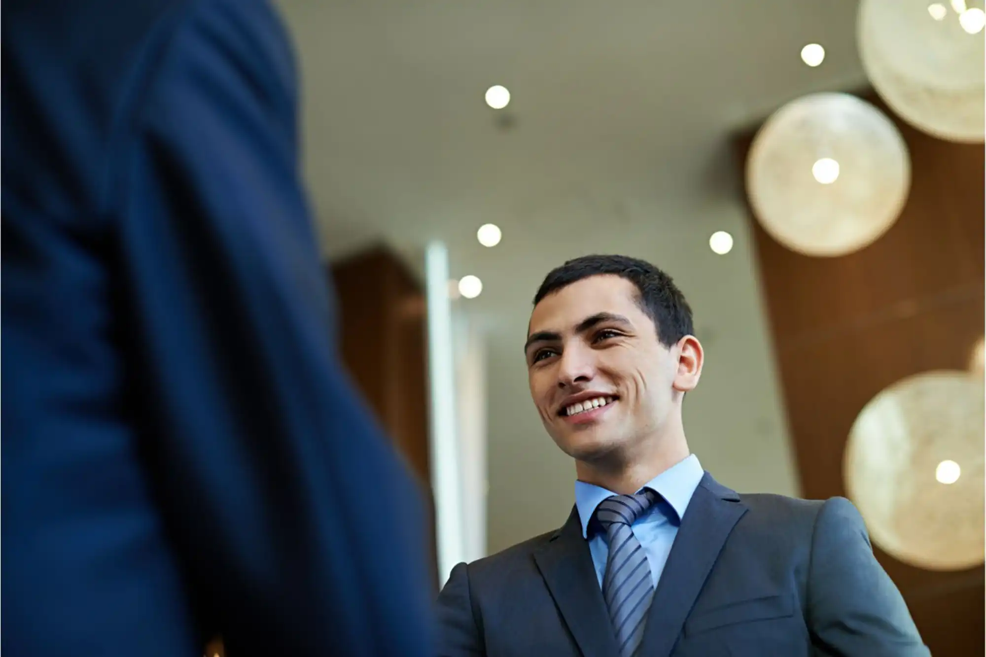 An apprentice in a suit shaking hands with a new employer