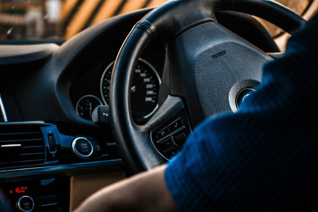 Mick is shown at the steering wheel of his car